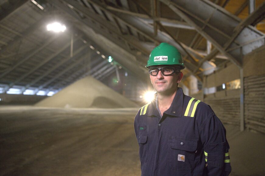 Man in front of fertilizer pile in Smart Nurtrien warehouse