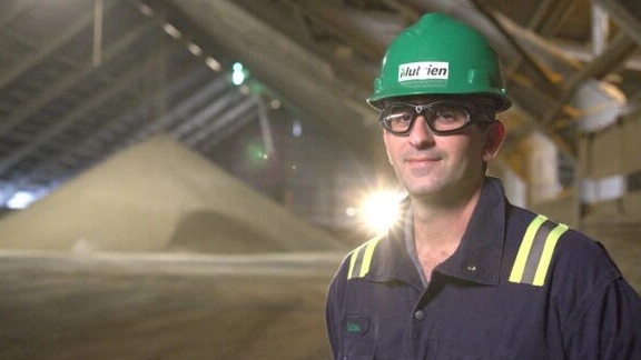 A Nutrien employee wearing protective gear in a manufacturing facility